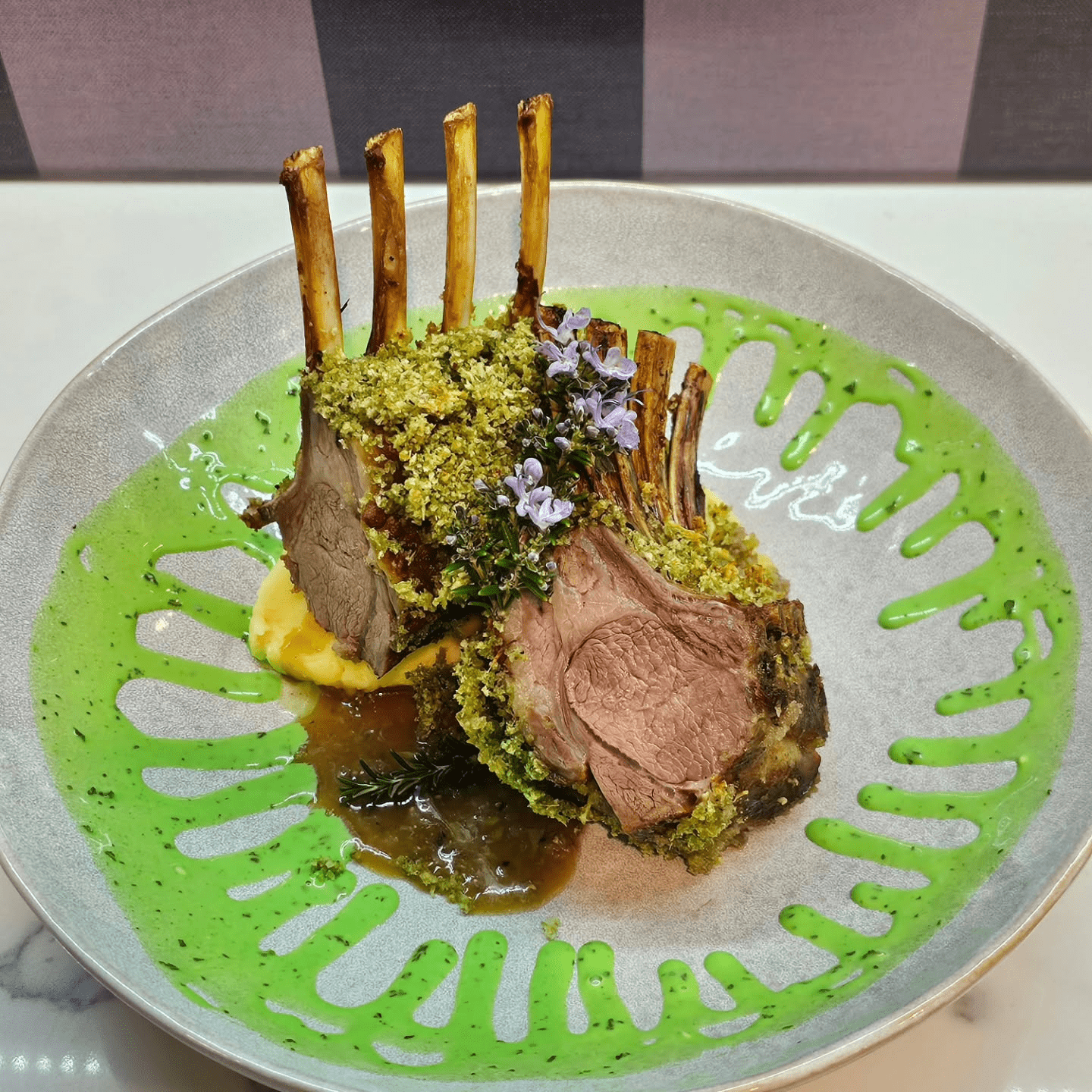 beautifully plated lamb rack crumbed mint sauce