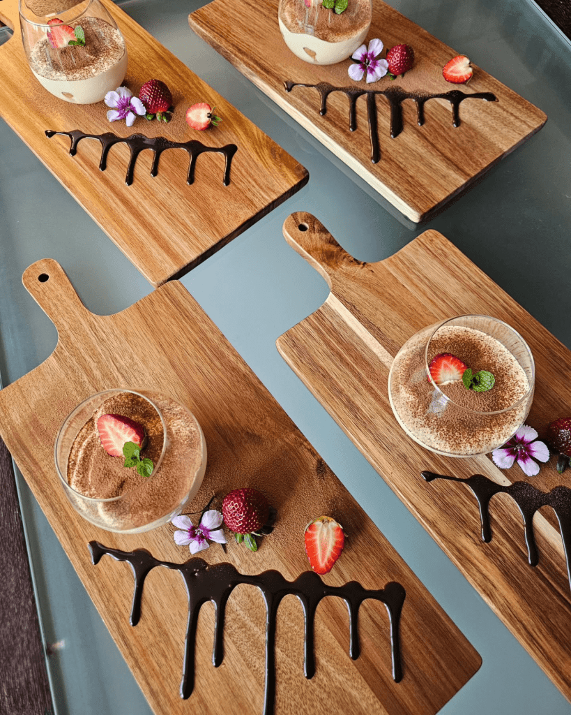 photo of coconut icecream with chocolate and strawberries presented on wooden boards