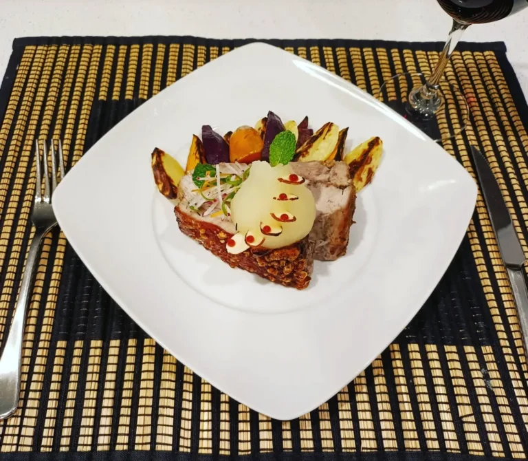 crispy pork belly with roasted vegetables and fine dining presentation
