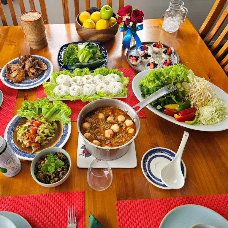 thai-family-style-dining-table-spread-noodles-curry-vegetables