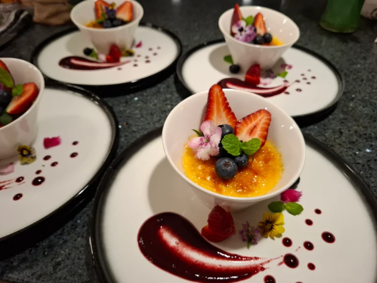 creme-brulee-dessert-plates-berry-coulis-blueberries-strawberries-edible-flowers