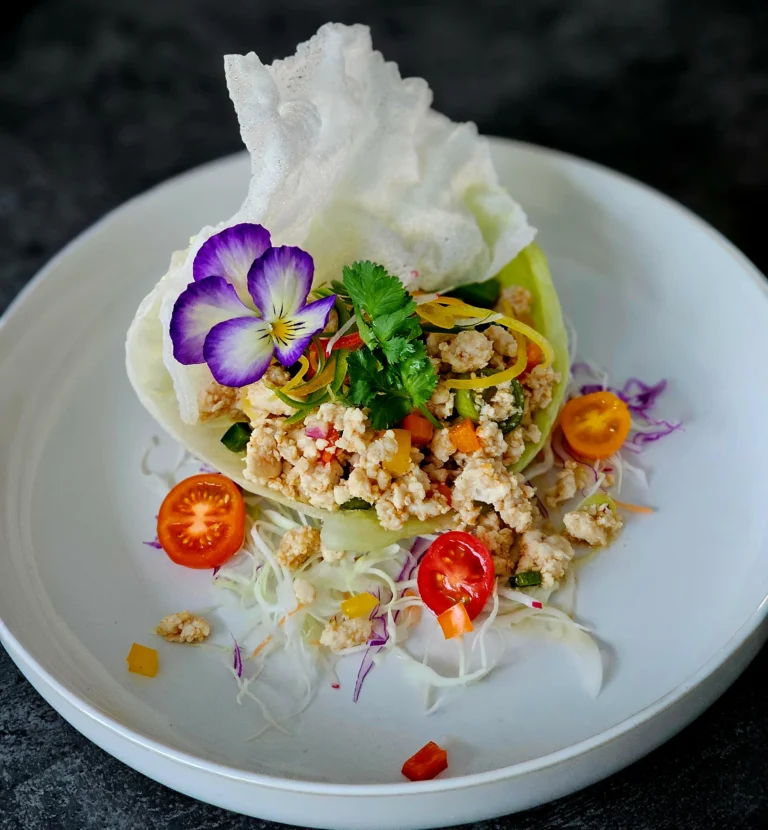 larb-chicken-lettuce-cup-edible-pansy-flower-prawn-cracker-plated-dish